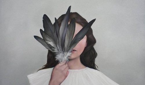 Kobieta zakrywa twarz piórami