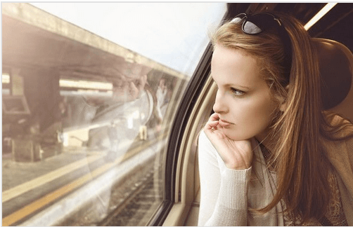 Kobieta patrząca przez szybę w pociągu