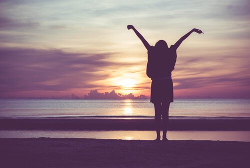 osoba na plaży wyciąga ręce