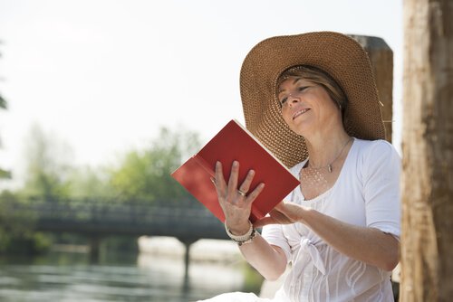 Kobieta w kapeluszu czyta książkę