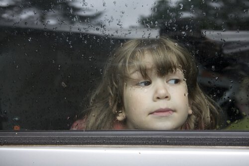 Smutna dziewczynka za oknem