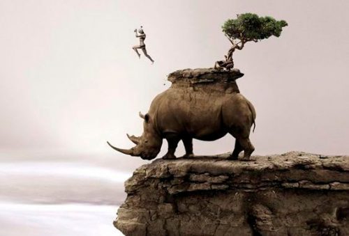 Człowiek skacze z nosorożca