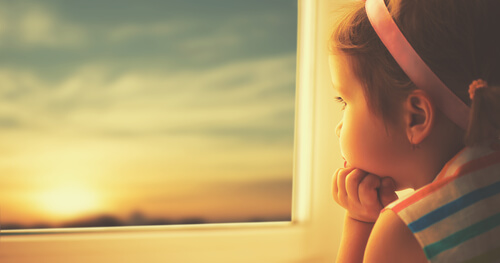 Mała dziewczynka patrząca przez okno