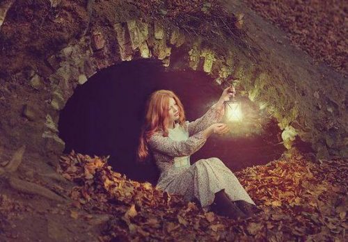 Kobieta trzymająca zapaloną latarnię