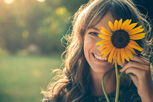 Uśmiechająca się kobieta z kwiatkiem