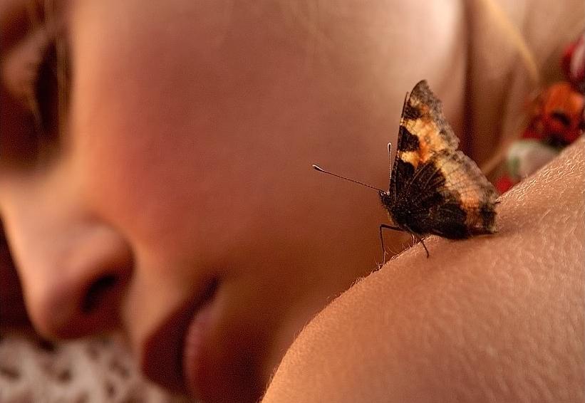Kobieta z motylem na ramieniu.