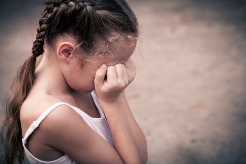 Uderzenie zadaje ból dziewczynce, która płacze, zakrywając twarz