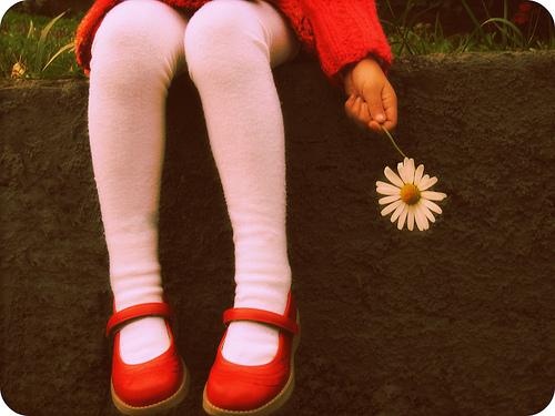 Dziewczynka z kwiatkiem w dłoni.