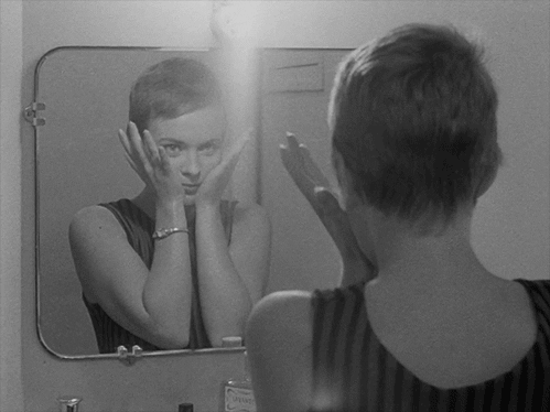 Dziewczyna patrzy na swoje odbicie w lustrze