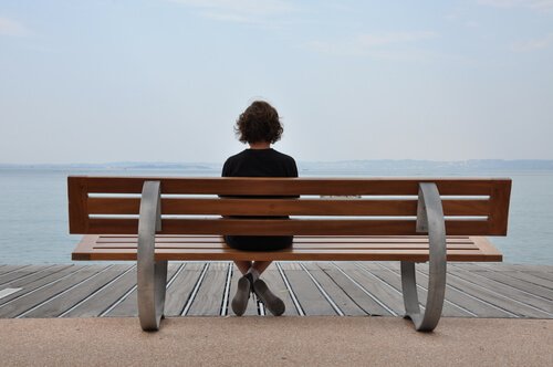Dziewczyna siedzi samotnie na ławce