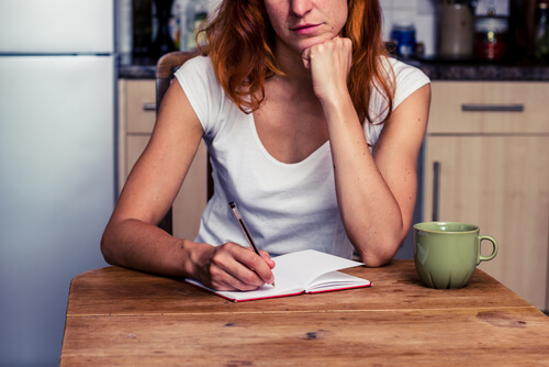 Kobieta pisze listę planów w notatniku