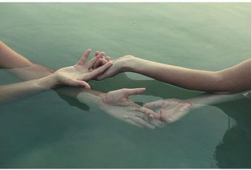 Dwie osoby trzymają się za ręce pod wodą
