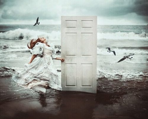 Dziewczyna na plaży stoi przy drzwiach