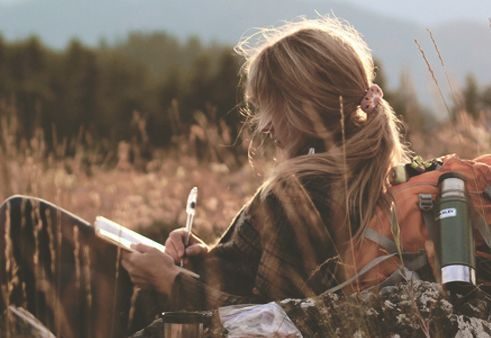 Kobieta pisze list w polu zboża
