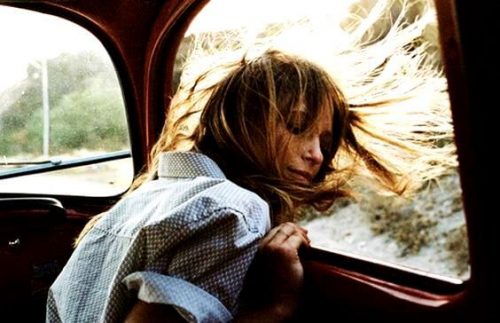 Szczęśliwa dziewczyna z rozwianymi włosami przy oknie w samochodzie