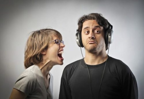 Ignorowanie problemu - kobieta krzyczy, mężczyzna słucha muzyki