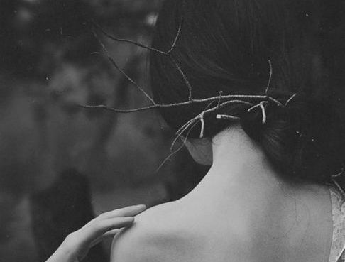 Bycie ofiarą - kobieta z gałązkami we włosach.