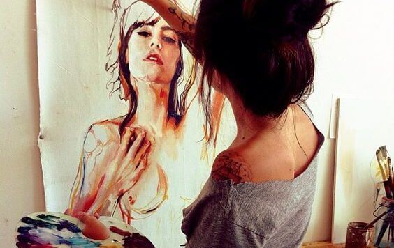 Dziewczyna malująca portret na ścianie.