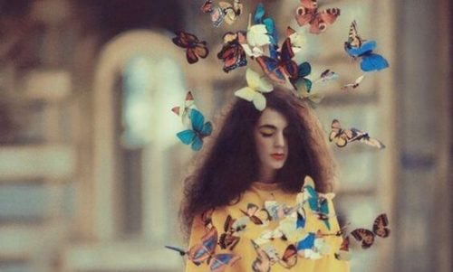 Dziewczyna i latające wokół niej motyle