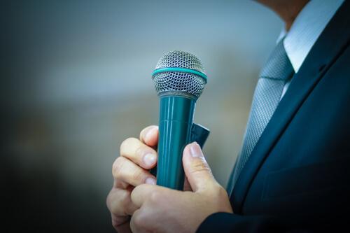 Człowiek trzyma mikrofon - strach przed wystąpieniami publicznymi