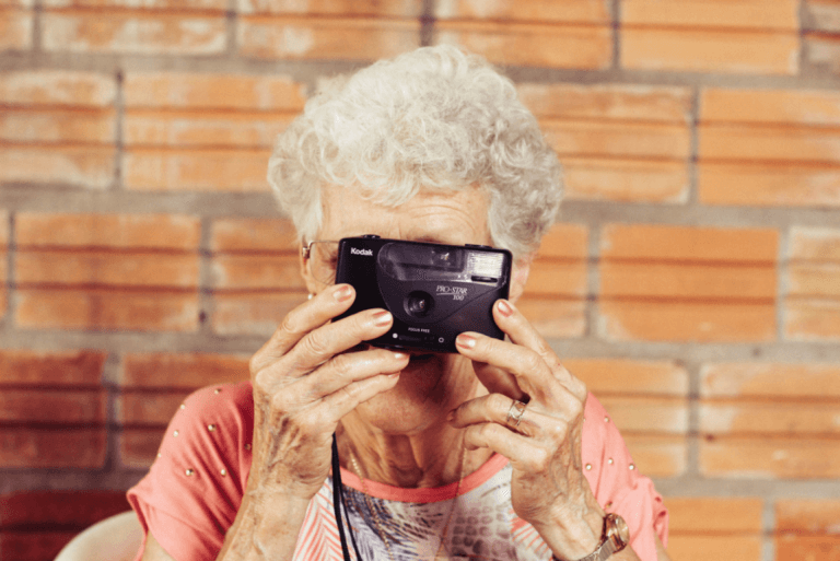 Starsza kobieta z aparatem fotograficznym.