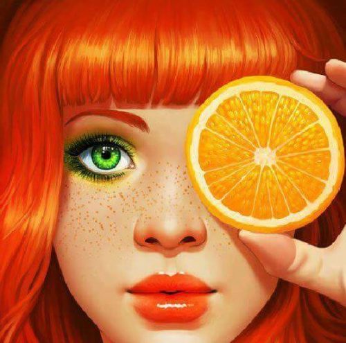 Pomarańczowy - ruda kobieta trzyma pomarańcz