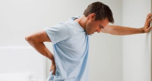 Zmęczony mężczyzna trzyma się za kręgosłup