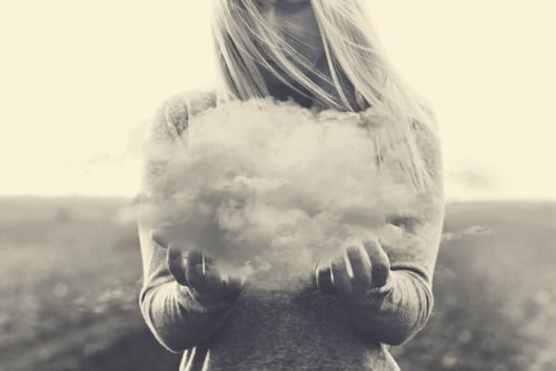 Kobieta trzyma chmurę symbolizującą natrętne myśli