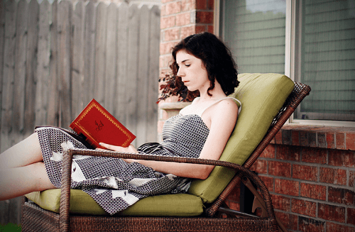 Kobieta czyta książkę na leżaku