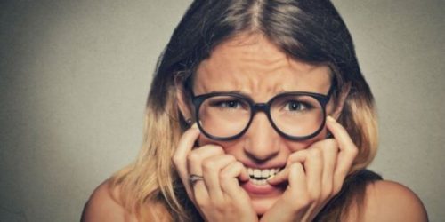 Kobieta obgryza paznokcie