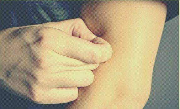 osoba szczypiąca się w ramię