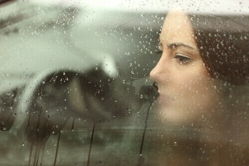 smutna kobieta patrząca przez okno
