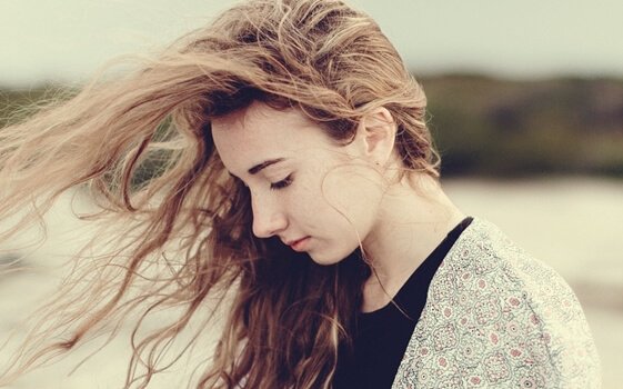 Dziewczyna z włosami rozwianymi przez wiatr.