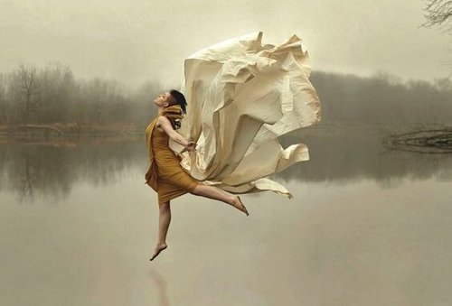 Kobieta skacząca nad powierzchnią jeziora