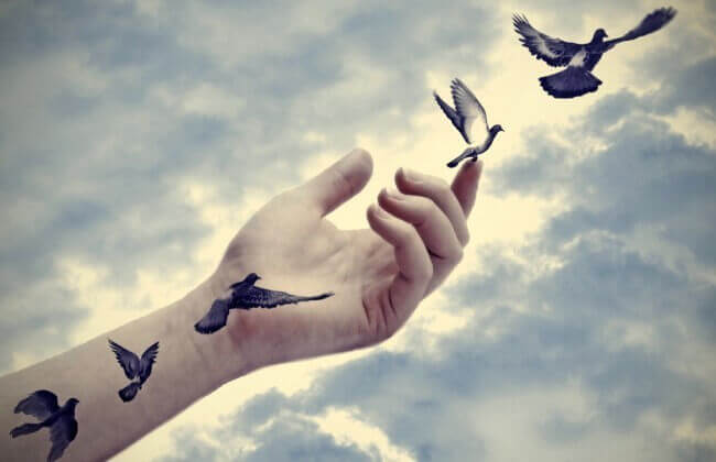 ręka wypuszczająca ptaki