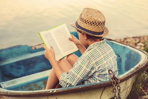 Książki wzmacniające wiarę w siebie u dzieci - Chłopiec czyta w łódce