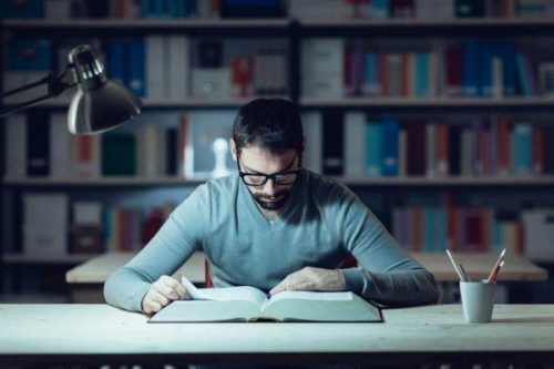 Jak uczyć się lepiej i efektywniej - skupiony mężczyzna w bibliotece