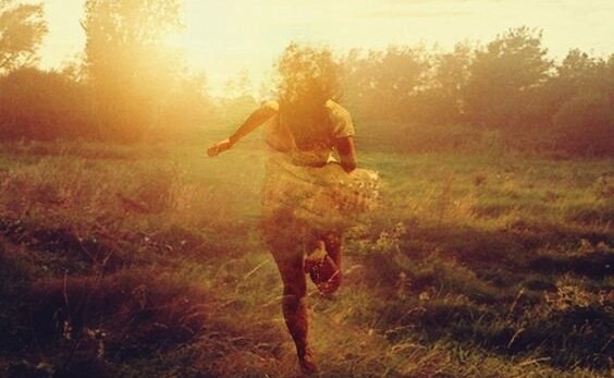 Kobieta biegnąca po łące.