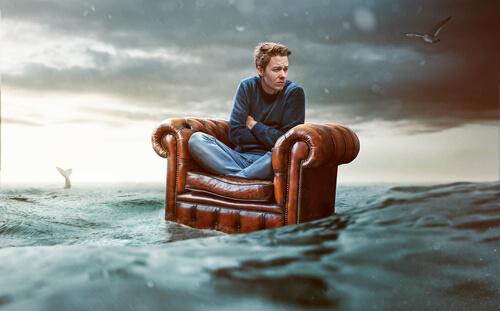 Mężczynza na fotelu na środku morza - fobia społeczna