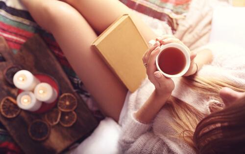 Herbatki relaksacyjne -kobieta pije podczas czytania książki