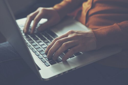 Kobieta pisząca na komputerze.