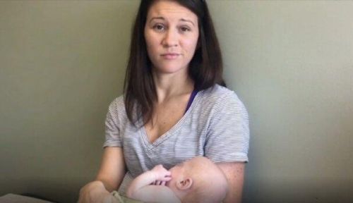 Mama ze skrzywioną miną trzyma dziecko