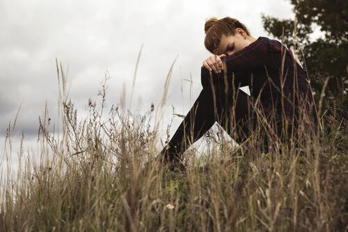 Depresja - kobieta siedzi na polu