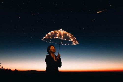 Uśmiechnięta kobieta pod oświetlonym parasolem