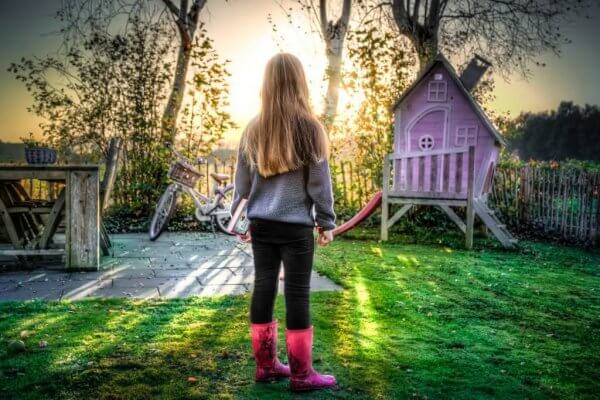 Dziewczynka i różowy domek do zabawy