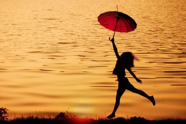 Kobieta biegnie z parasolem - pragmatyczny optymizm