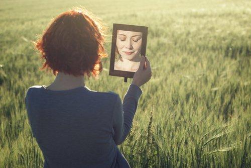 Kobieta na polu patrzy w małe lustro