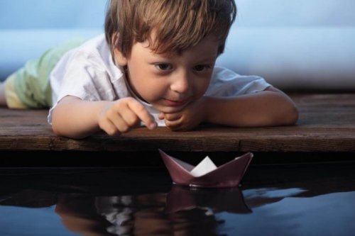 chłopiec z papierową łódką