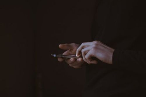 cyberprzemoc człowiek ze smartfonem w dłoniach