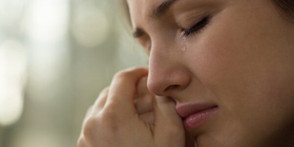 kobieta wysuszająca łzy